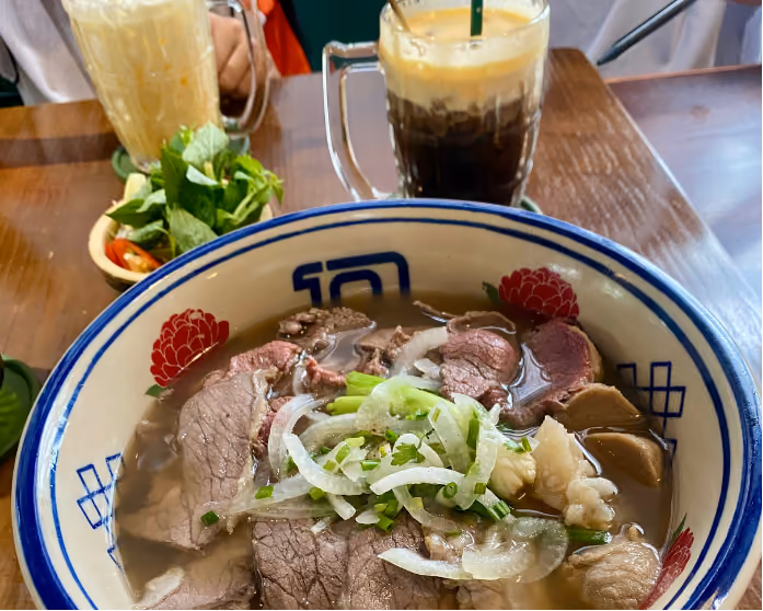 Soup pho served in hot stone with uncooked meat at Roka vietnamese restaurant in Phnom Penh